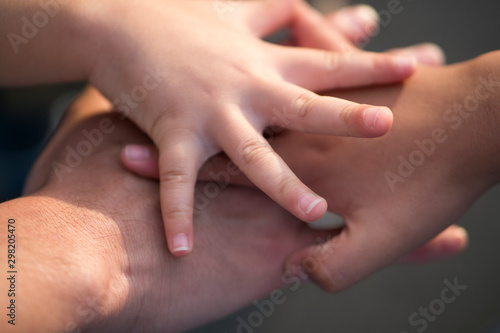 Close-up of father and children's hands holding together as a team.