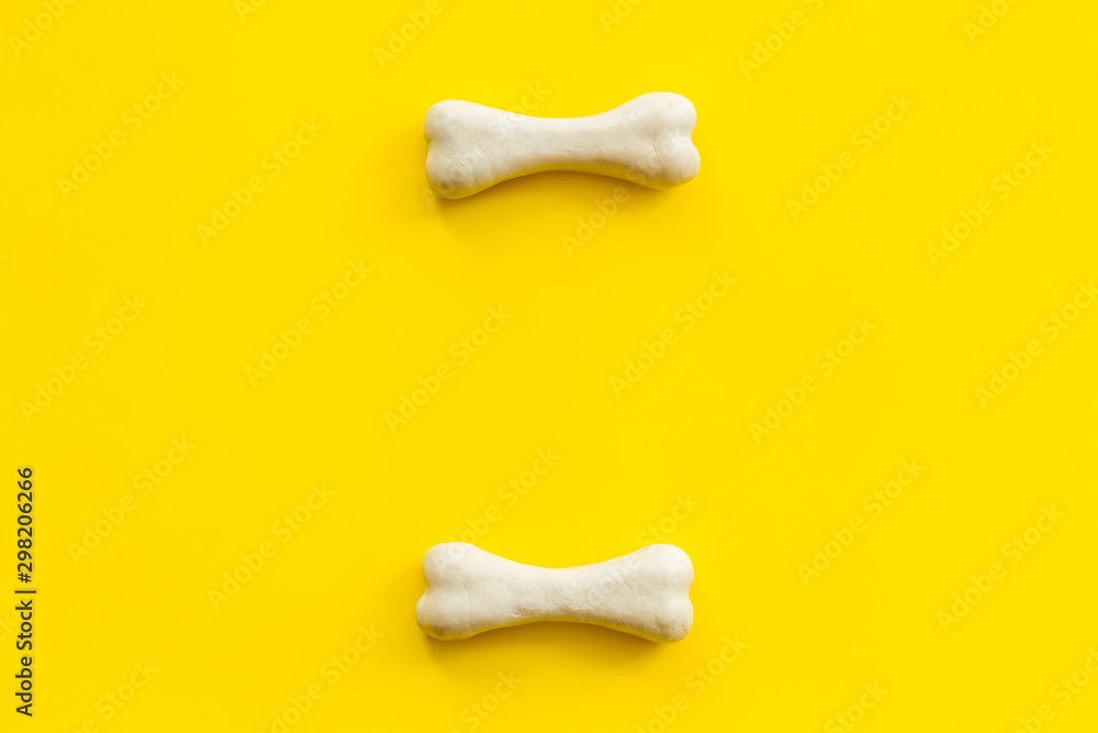 Obraz premium Treats for dogs. Chewing bones on yellow background top view copy space