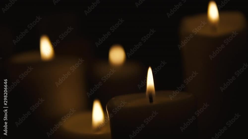 Static shot on fired candles from above, composition on a black background, slow movement of flames on a black note, slow motion Static shot on fired candles from above, composition on a black background, slow movement of flames on a black note, slow motion