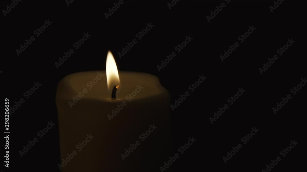 Static shot of one lighted candle, composition on black background, slow motion Static shot of one lighted candle, composition on black background, slow motion