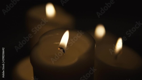 Wallpaper Mural Slow movement over burning candles, composition on black background, candles of different sizes stand side by side, slow motion Torontodigital.ca