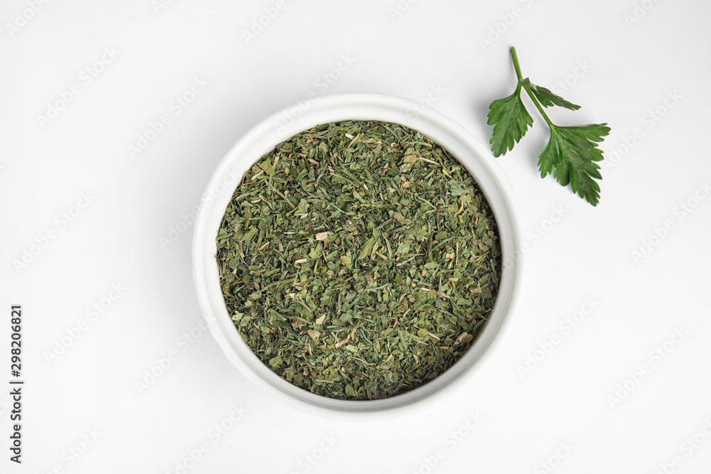 Bowl with dried parsley and fresh twig on white background, top view Bowl with dried parsley and fresh twig on white background, top view