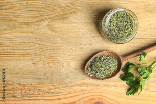 Flat lay composition with fresh and dried parsley on wooden table. Space for text