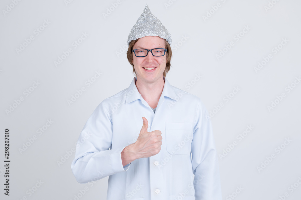 Happy young man doctor with tinfoil hat giving thumbs up Happy young man doctor with tinfoil hat giving thumbs up