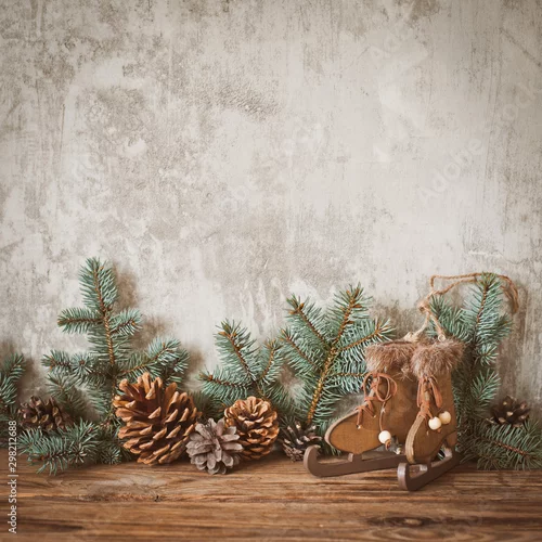 Obraz Choinka rozgałęzia się z rożkami na ciemnej drewnianej desce przeciw szarej betonowej ścianie.