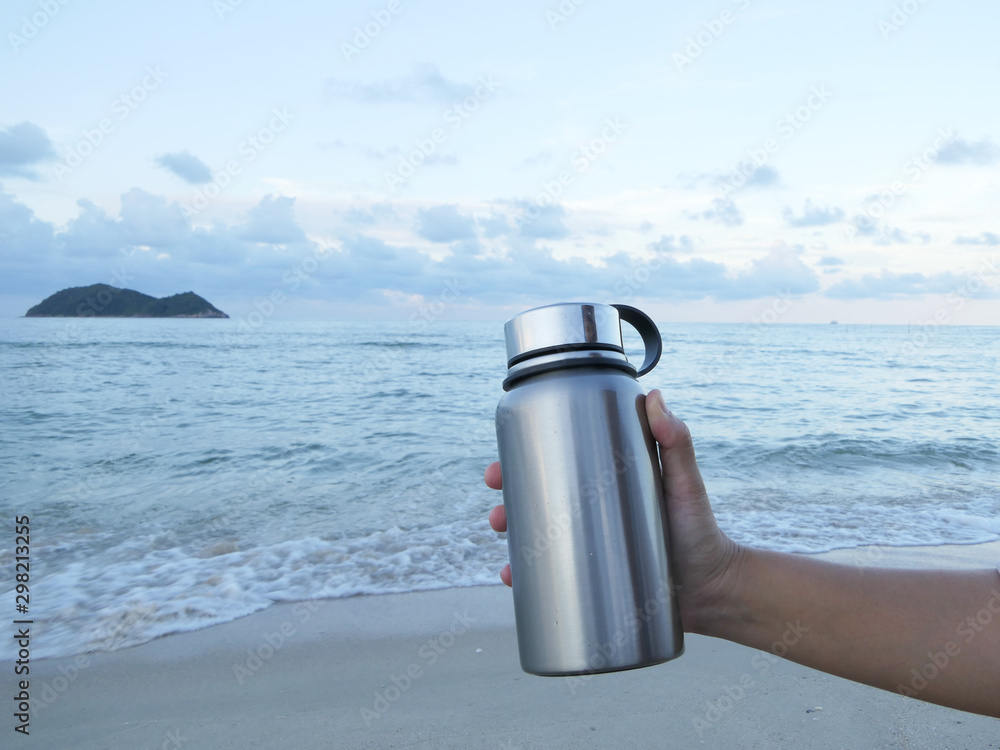 Closeup Of A Glass Reusable Water Bottle On The Seashore Of A