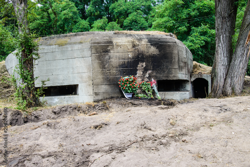 A basket of flowers is placed near the embrasure. DOT (long-term defensive point). Defensive DOT 401 near Kiev. The turn of defense 1941 with. Bilogorodka. Kiev. Ukraine. June 23, 2019 A basket of flowers is placed near the embrasure. DOT (long-term defensive point). Defensive DOT 401 near Kiev. The turn of defense 1941 with. Bilogorodka. Kiev. Ukraine. June 23, 2019