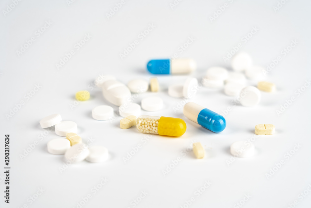 Many little white tablets and colorful tablet capsules on white background Many little white tablets and colorful tablet capsules on white background