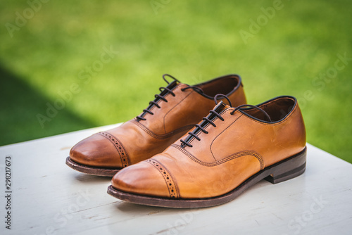 Elegant brown leather male shoes on a grass background