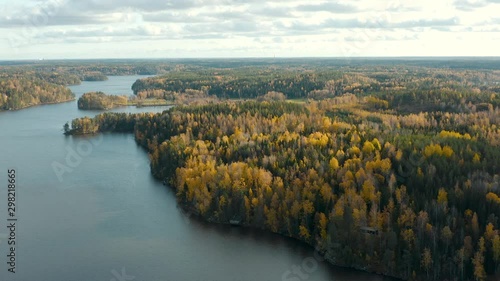 Aerial, drone shot, over lake Nuuksion Pitkajarvi, towards colorful, foliage forest, in Nuuksio national park, on a sunny, autumn day, in Espoo, Uusimaa, Finland photo