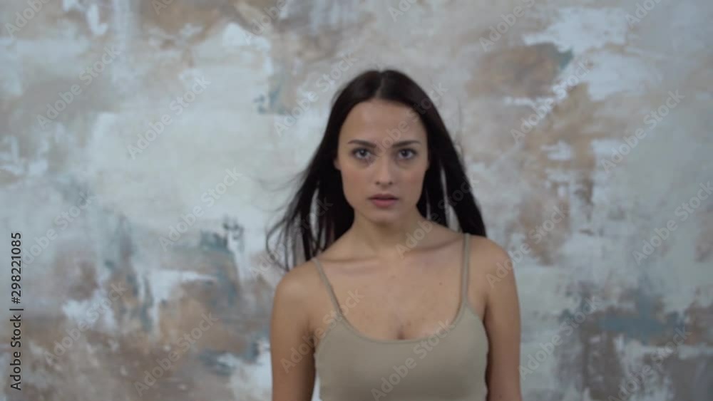 Young woman alone isolated on gray changing facial expression Young woman alone isolated on gray changing facial expression