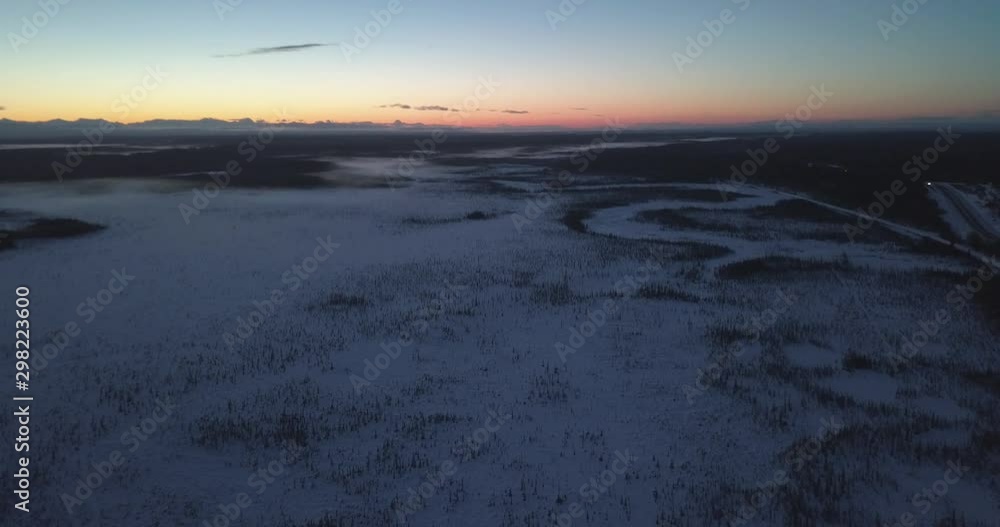 Panning Up Drone Shot flying over an Alaskan countryside with a beautiful sunset on the horizon. Panning Up Drone Shot flying over an Alaskan countryside with a beautiful sunset on the horizon.