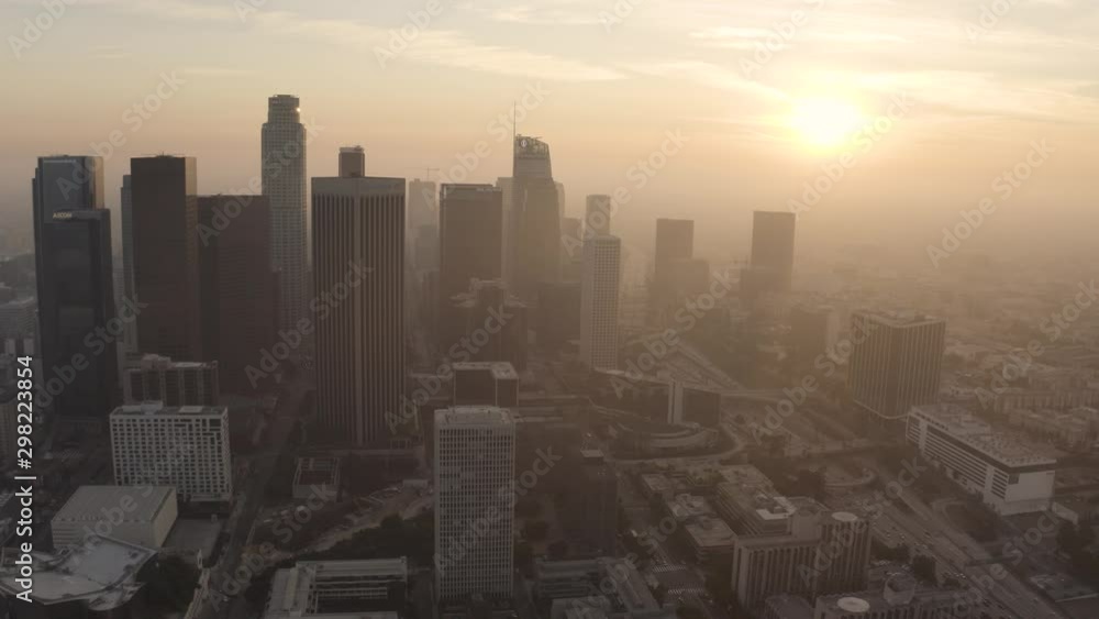 Golden Hour aerial shot flying high above the tall skyscrapers and high rises in downtown Los Angeles, California. Shot during a beautiful sunset. Golden Hour aerial shot flying high above the tall skyscrapers and high rises in downtown Los Angeles, California. Shot during a beautiful sunset.