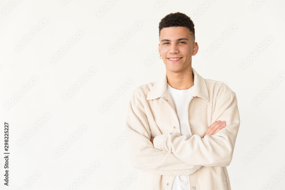 Cheerful man standing with crossed arms. Portrait of handsome confident young man standing with crossed arms and looking at camera. Facial expression concept Cheerful man standing with crossed arms. Portrait of handsome confident young man standing with crossed arms and looking at camera. Facial expression concept