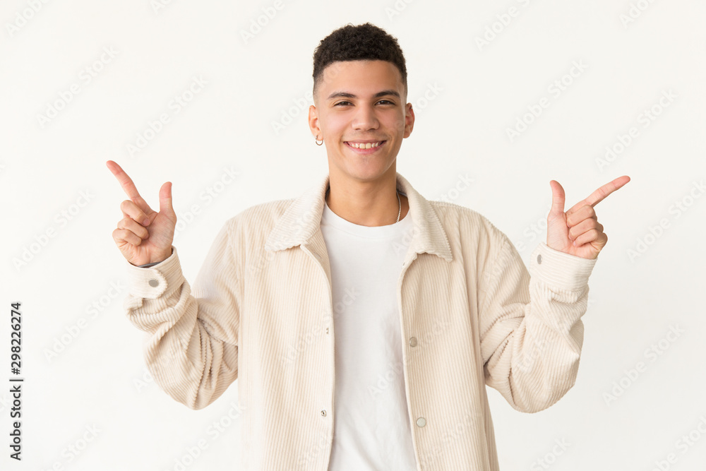 Cheerful man pointing with fingers. Portrait of handsome happy young man gesturing with hands and smiling at camera. Gesture concept Cheerful man pointing with fingers. Portrait of handsome happy young man gesturing with hands and smiling at camera. Gesture concept