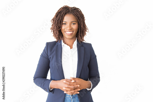 Happy cheerful female consultant looking at camera. Young African American business woman with clasped hands standing isolated over white background, smiling. Happy entrepreneur concept