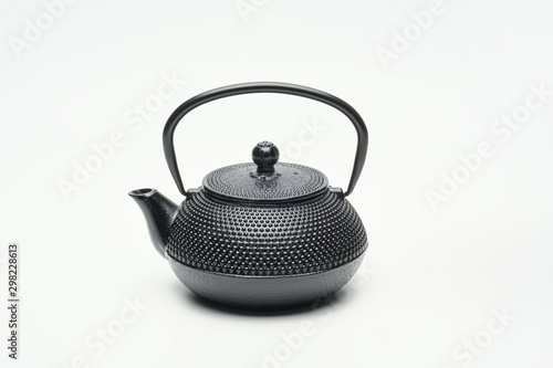 Black cast iron teapot on a white background.