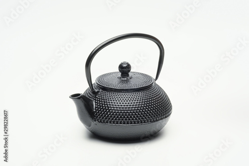 Black cast iron teapot on a white background.