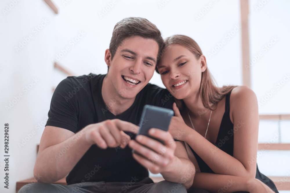 loving young couple sitting on the steps in their apartment loving young couple sitting on the steps in their apartment