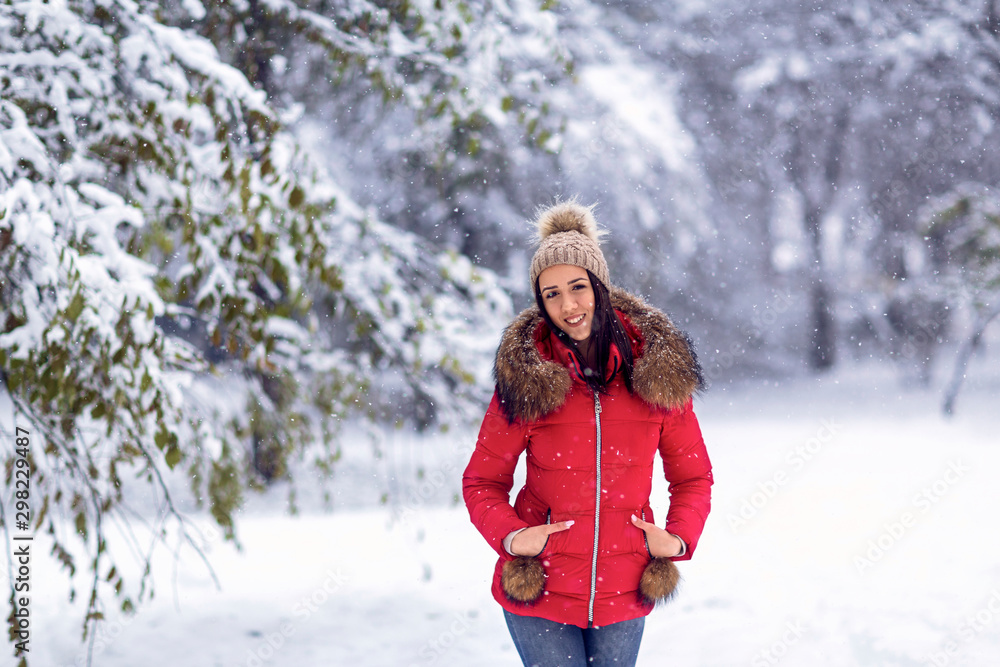 Beautiful woman standing among snowy trees in winter forest and enjoying snow. Beautiful woman standing among snowy trees in winter forest and enjoying snow.