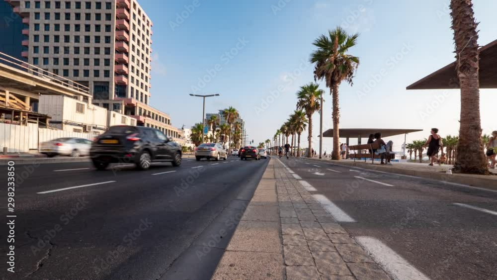 Low angle rising timelapse of a busy street along side a boardwalk in Tel Aviv, Israel with cars, cyclists, and pedestrians on a summer day. Low angle rising timelapse of a busy street along side a boardwalk in Tel Aviv, Israel with cars, cyclists, and pedestrians on a summer day.