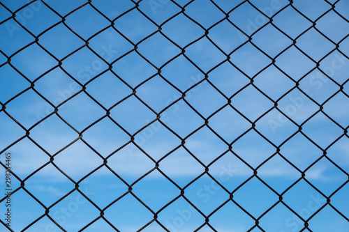 Security with a barbed wire fence in foreground and blue sky in background
