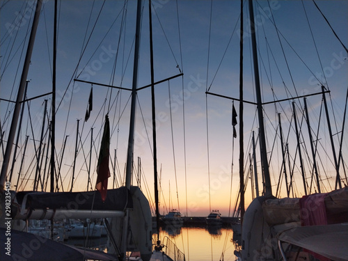 Fototapeta Naklejka Na Ścianę i Meble -  Nice sunset in quiet sea marina with sail boats silhouettes 