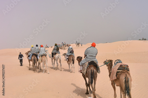 Bedouins in traditional clothes riding camels in sahara desert  Tunis.