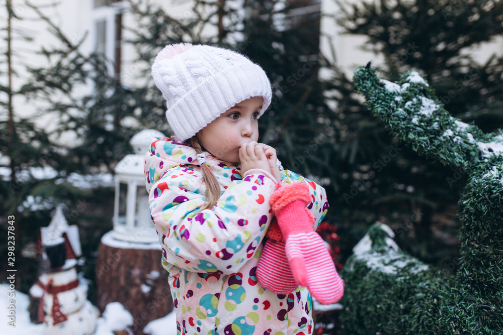 Little cute pretty girl in winter snowy park playing outdoors. Happines, joy, childhood, winetr, chistmas concept