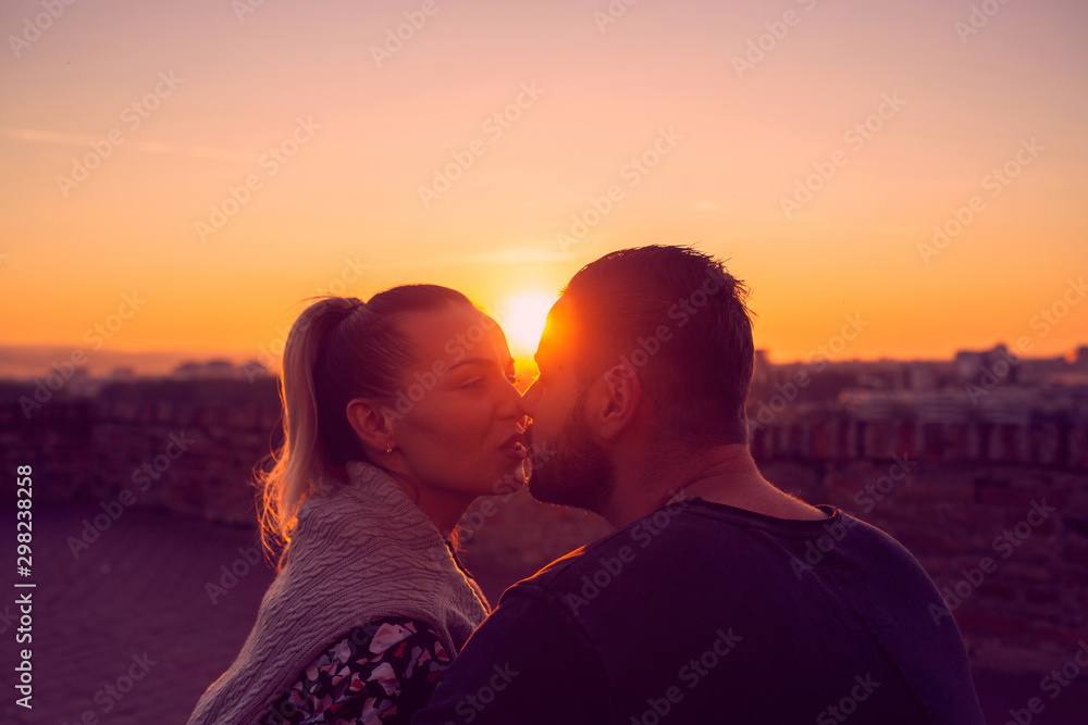 Couple in love kissing at evening  in sunset