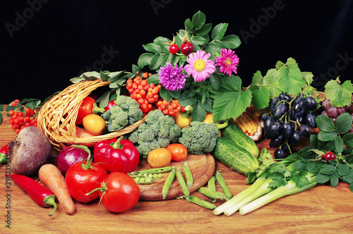 Fototapeta Naklejka Na Ścianę i Meble -  Vegetables in a basket and flowers on a wooden table. Thanksgiving
