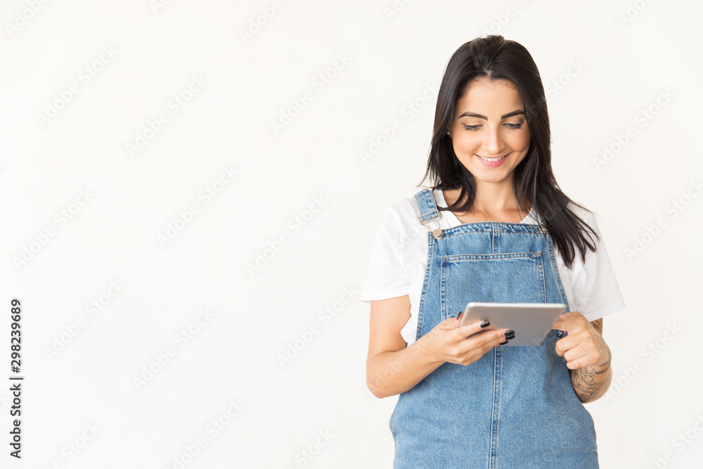 Smiling woman using tablet pc, Beautiful cheerful young brunette woman using digital tablet isolated on white background. Wireless technology concept Smiling woman using tablet pc, Beautiful cheerful young brunette woman using digital tablet isolated on white background. Wireless technology concept