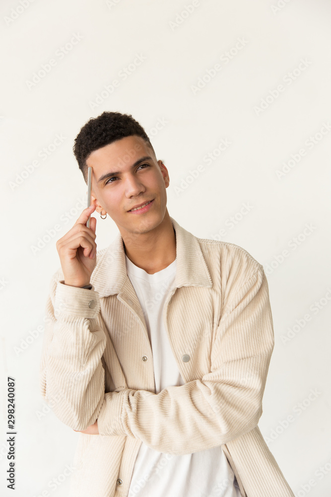 Pensive man holding pen and looking up. Portrait of thoughtful handsome young man holding pen near forehead and looking away. Facial expression concept Pensive man holding pen and looking up. Portrait of thoughtful handsome young man holding pen near forehead and looking away. Facial expression concept