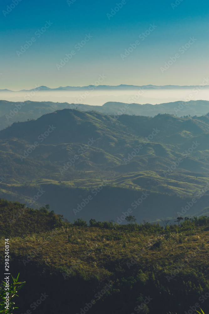 GREEN GRASS ON FOREGROUND AND THE MOUNTAIN STAND ON THE MIDDLE AND THE CLOUDS BEYOND THE MOUNTAIN GREEN GRASS ON FOREGROUND AND THE MOUNTAIN STAND ON THE MIDDLE AND THE CLOUDS BEYOND THE MOUNTAIN