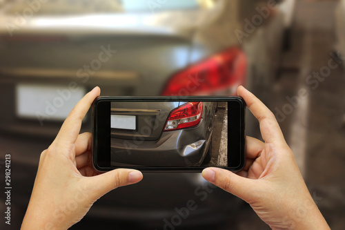 Close up hand holding smartphone and take photo at The scene of a car crash and accident, car accident for car insuranc claim photo