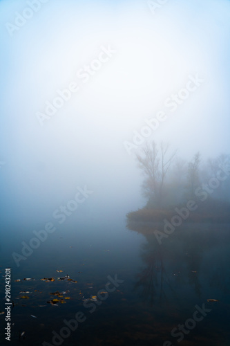 Pond covered in fog during autumn morning
