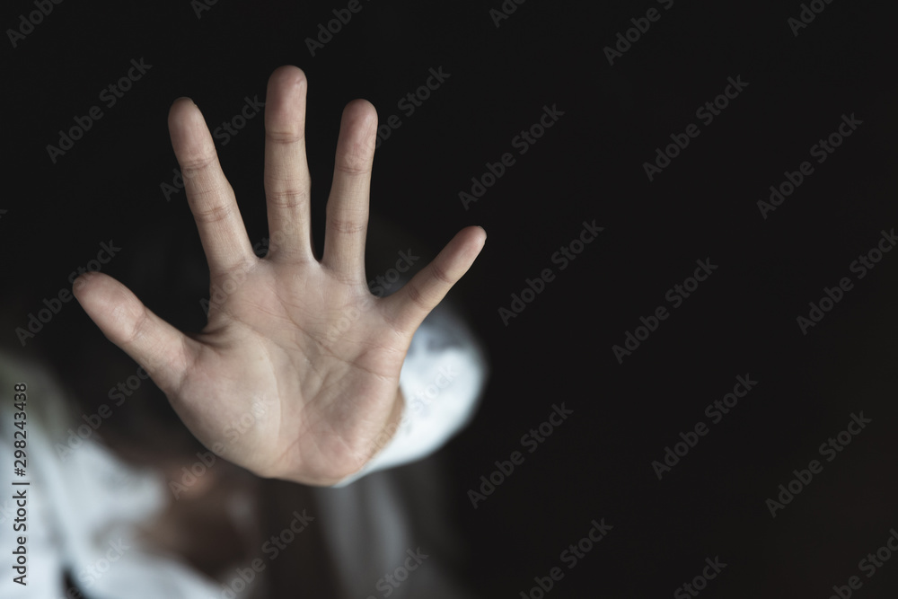 Woman's hand extended signaling to stop useful to campaign against violence, gender or sexual discrimination Woman's hand extended signaling to stop useful to campaign against violence, gender or sexual discrimination