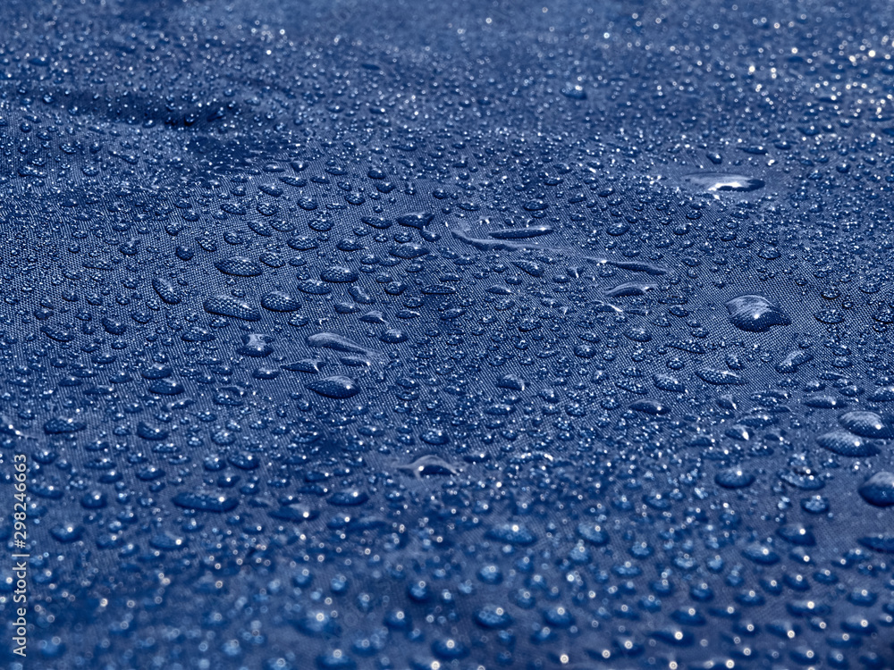 Obraz premium Rain water droplets on blue fiber waterproof fabric. Blue background.