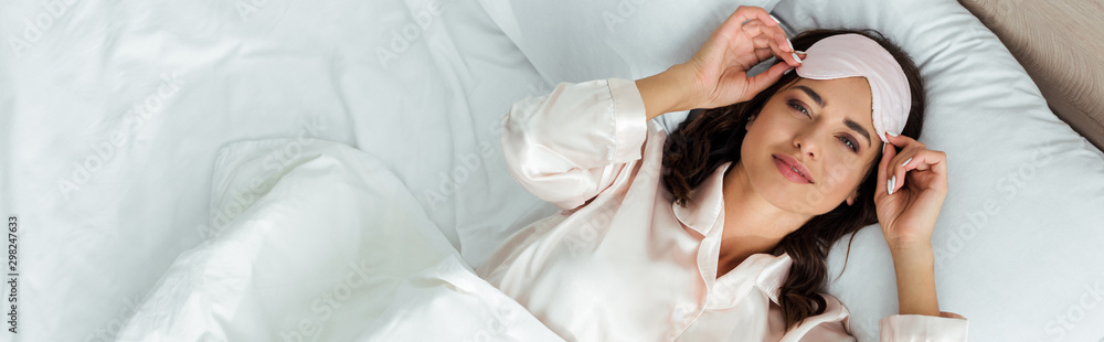 panoramic shot of attractive woman with sleeping mask looking at camera at morning - obrazy, fototapety, plakaty 