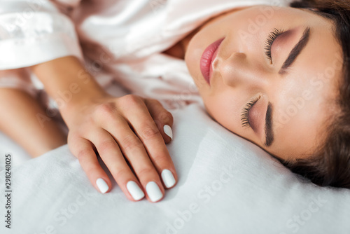 selective focus of attractive woman sleeping in bed at morning