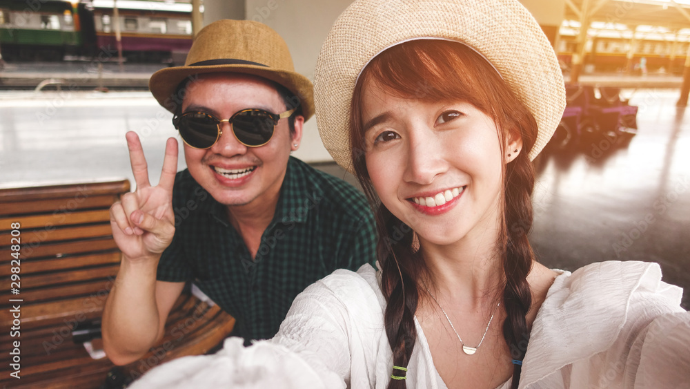 Couples ,women and asian man take a selfie with a smiling face. Looks cute and in a good mood while waiting for the train