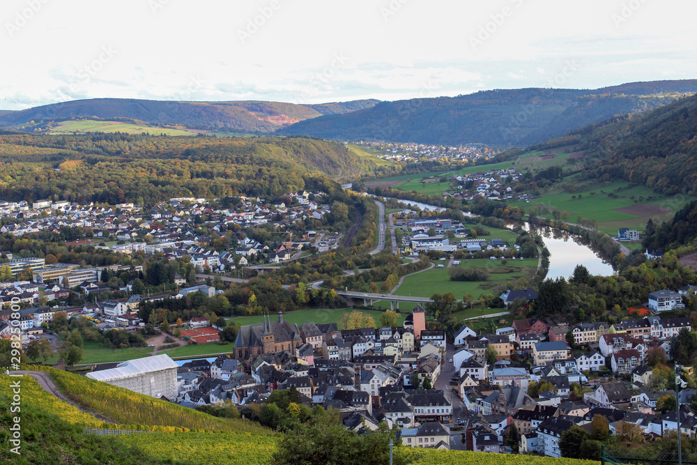 Fototapeta premium View on the Saar river and Saarburg town from vineyards hills near Saarburg, West Germany. October, autumn.
