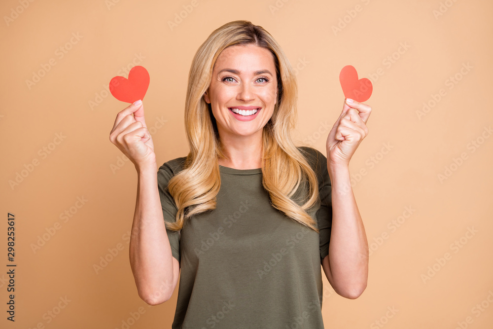 Photo of cheerful cute nice pretty positive glad pleased girlfriend smiling toothily wearing green t-shirt holding two small hearts she received from her beloved one isolated pastel color background Photo of cheerful cute nice pretty positive glad pleased girlfriend smiling toothily wearing green t-shirt holding two small hearts she received from her beloved one isolated pastel color background