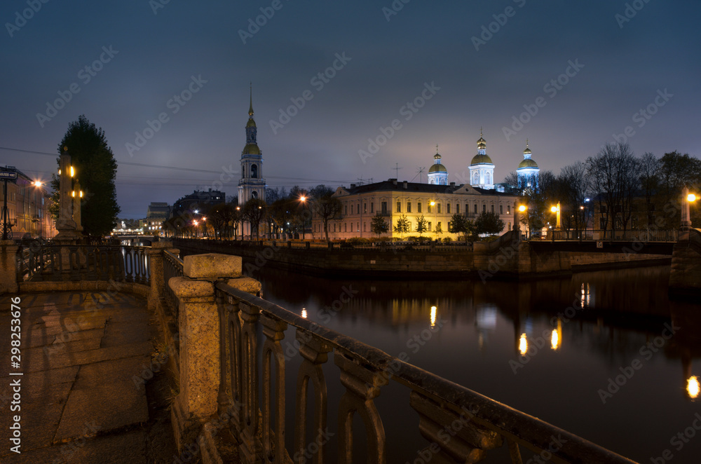 Night landscape with St. Nicholas Naval Cathedral and and the bell tower reflected in the water channel (Saint Petersburg, Russia)