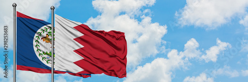 Belize and Bahrain flag waving in the wind against white cloudy blue sky together. Diplomacy concept, international relations.