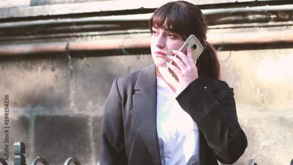 Business woman working and talking on the phone. Workflow on the way to work. Black suit. Stylish girl Business woman working and talking on the phone. Workflow on the way to work. Black suit. Stylish girl
