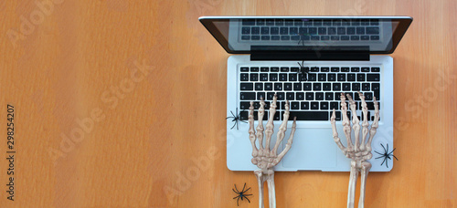 Skeleton hands typing on laptop