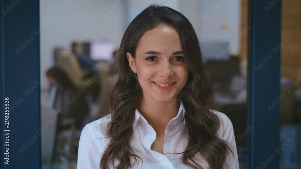 portrait of young business woman smiling looking at camera happy enjoying successful career in office workspace background portrait of young business woman smiling looking at camera happy enjoying successful career in office workspace background