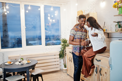 Photography Afro american couple sweethearts drinking wine in kitchen at their romantic date