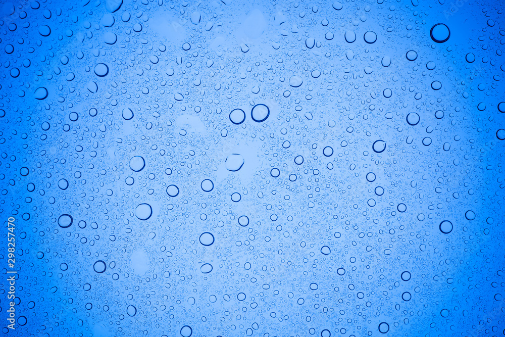 Rain droplets on blue glass background, Water drops on blue glass.